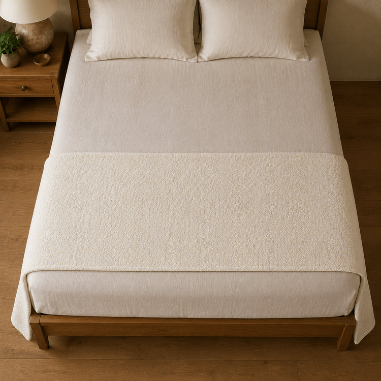 Ivory Bouclé bed runner viewed from above across the foot of a bed