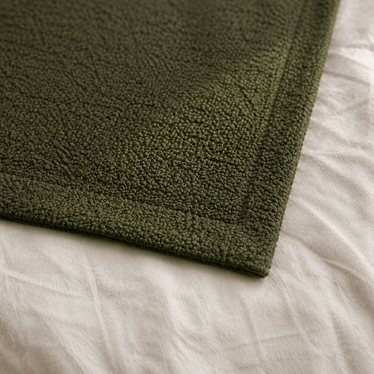 Close-up of Moss Green Bouclé texture and finished edge