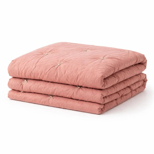 Handmade Cotton Velvet Quilt in Blush Pink, folded on bed